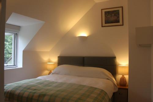 um quarto com uma cama com duas luzes acesas em Coot Cottage em Somerford Keynes