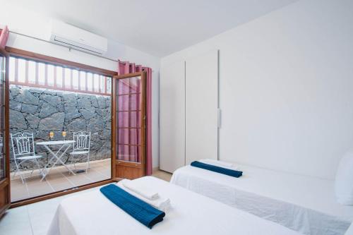 two beds in a room with a view of a patio at Villa Vista Reina - Luxury 6 Bedroom - Heated Pool- Views - Pool Table - Vista Lobos - Playa Blanca in Playa Blanca