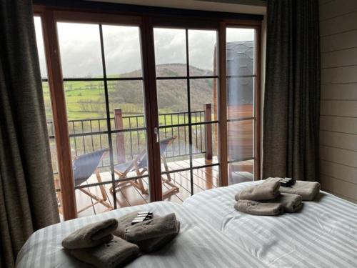 een slaapkamer met een bed met handdoeken en een balkon bij Suites de la vallée 6 in Érezée