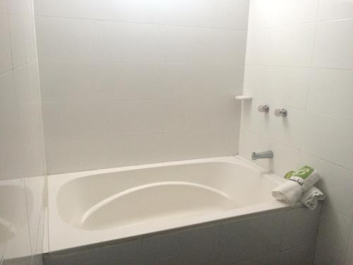 a bath tub in a bathroom with a towel on it at Hotel Bucaramanga Plaza in Bucaramanga