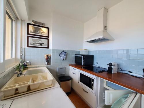 une petite cuisine avec un évier et une cuisinière dans l'établissement FREJUS PLAGE Tour Mediterranee 10e Etage T2 38m2, à Fréjus