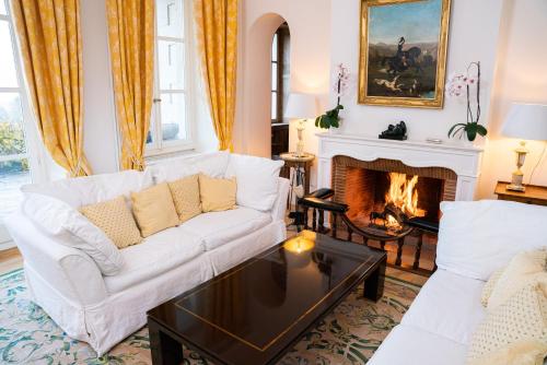 a living room with a white couch and a fireplace at Chateau d'Echenevex - Luxury Escape near Geneva in Échenevex