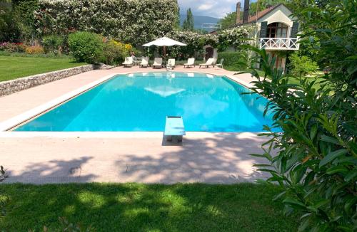 a large blue swimming pool in a yard at Chateau d'Echenevex - Luxury Escape near Geneva in Échenevex