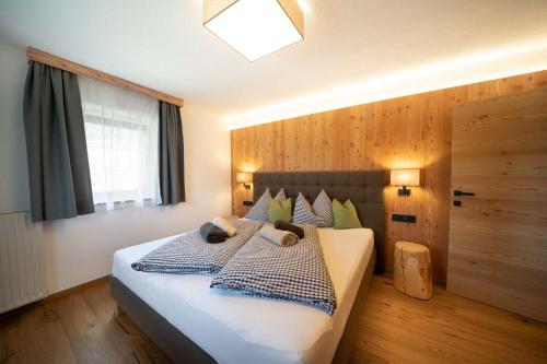 una camera da letto con un grande letto bianco con cuscini blu di Pliegermoar in Völs am Schlern a Fié allo Sciliar