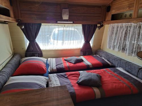 dos camas en la parte trasera de una caravana en GLAMPING HOUSE RANČ LUŽE en Luže