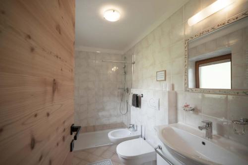 uma casa de banho com um lavatório, um WC e uma banheira em Pliegermoar in Völs am Schlern em Vols am Schlern
