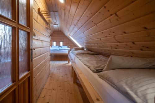 a room with two beds in a wooden room at Penzion Koucký in Bedřichov