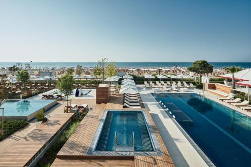 Blick auf den Pool in einem Resort mit Strand in der Unterkunft Falkensteiner Hotel & Spa Jesolo in Lido di Jesolo