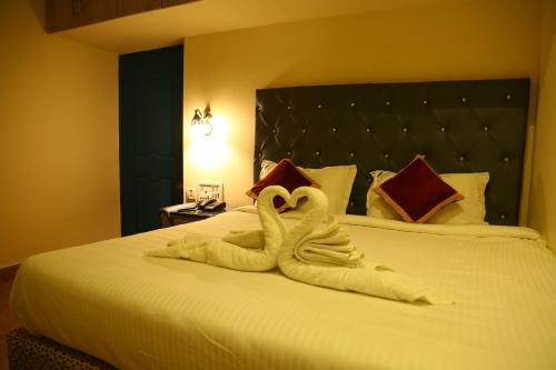 two swans made out of towels on a bed at Zingle Stay Airport Hotel in Chennai