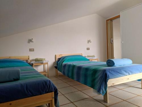 a room with two beds with blue sheets on them at RESIDENZA GATTO SILVESTRO A 2 MINUTI DAL MARE E DALLA FIERA in Rimini