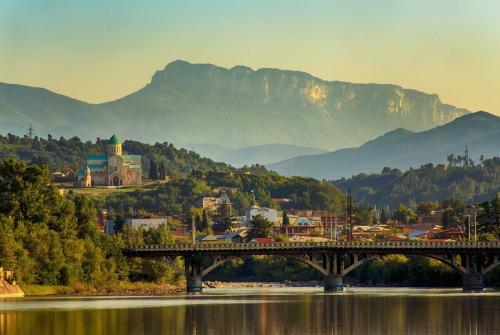 a bridge over a river with mountains in the background at Veli group Apartment near White Bridge ° in Kutaisi