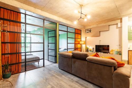 a living room with a couch and a large window at Veli group Apartment near White Bridge ° in Kutaisi