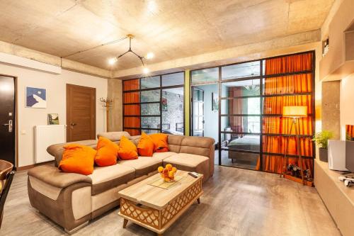 a living room with a couch with orange pillows at Veli group Apartment near White Bridge ° in Kutaisi