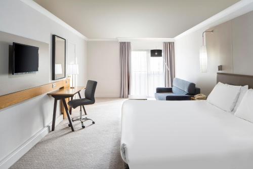 a hotel room with a bed and a desk and a tv at Crowne Plaza Plymouth by IHG in Plymouth