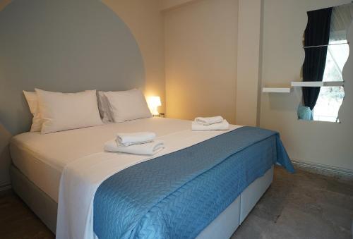 een slaapkamer met een bed met twee handdoeken erop bij Antàma Apartments in Skriperón