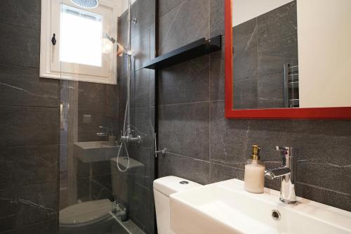 a bathroom with a sink and a toilet and a mirror at Antàma Apartments in Skriperón