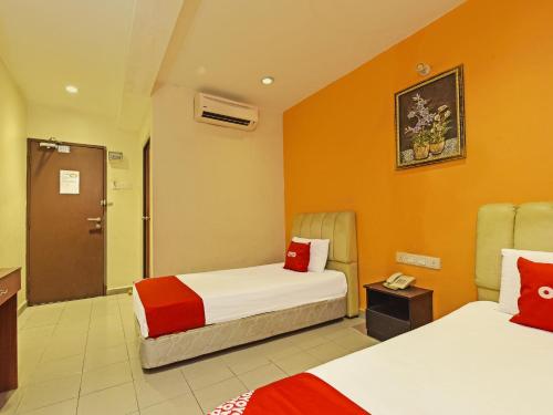 a hotel room with two beds with orange walls at OYO 90510 Hotel Sahara in Johor Bahru