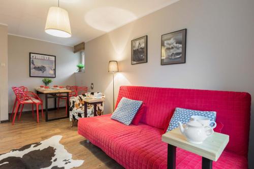 a living room with a red couch and a table at Apartament Tosia Zakopane in Zakopane