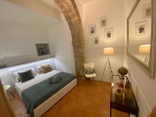 um quarto com uma cama e uma cadeira num quarto em U Dammusu em Siracusa