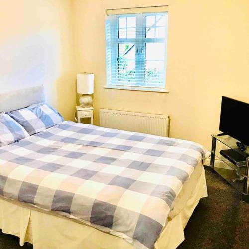 a bedroom with a bed and a window and a television at Semi-detached Armagh House in Armagh