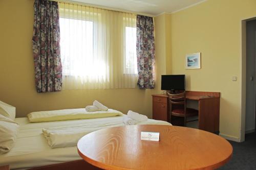 a hotel room with two beds and a table at Autobahn Hotel Pfungstadt Ost in Pfungstadt