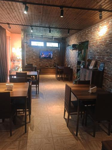 a restaurant with tables and chairs and a brick wall at Guest House on V. Pshavela 50 in Stepantsminda