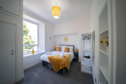 a white bedroom with a bed and a window at Baker Apartment - Lovely 2-bedroom apartment in Aberdeen City in Aberdeen