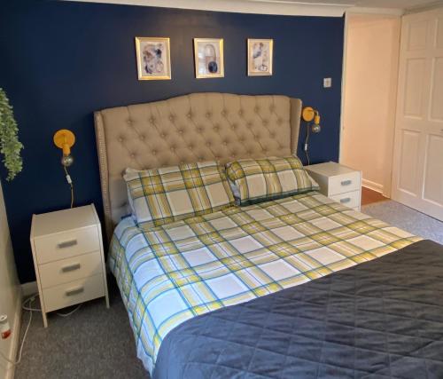 a bedroom with a bed with a blue wall at 1 bedroom apartment with own entrance and parking space in Huntingdon