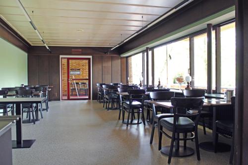 a dining room with tables and chairs and windows at Autobahn Hotel Pfungstadt Ost in Pfungstadt