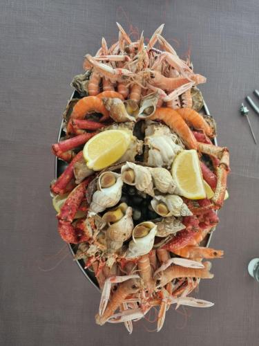 a pile of seafood with lemon slices on top at Le calme in Plessé