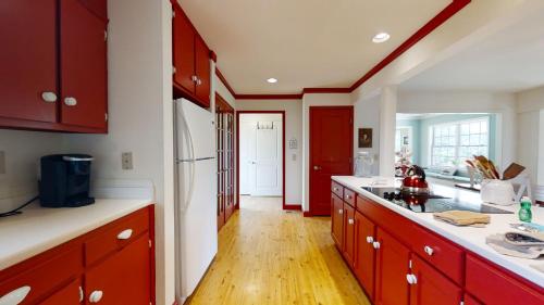 a kitchen with red cabinets and a wooden floor at Two-Bedroom House in Townsend