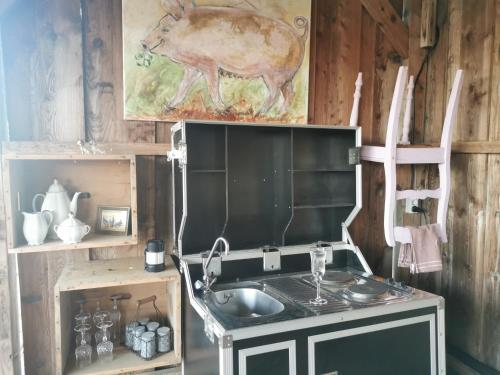 a kitchen with a sink and a picture of a cow at Lavendelmond Glamping in Barntrup