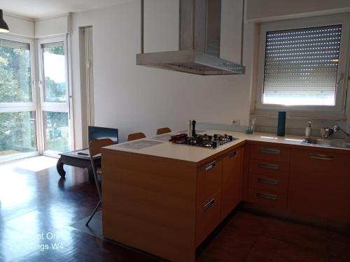 a kitchen with wooden cabinets and a stove top oven at Appartamento DeLuxe con parcheggio gratuito in Segrate