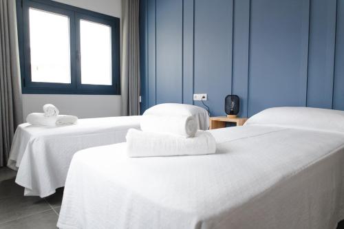 a room with two beds with towels on them at Hostal Náutico de Razo in Carballo