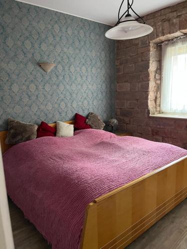 a bedroom with a large bed with a purple blanket at Haus Bell in Trippstadt