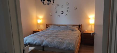 - une chambre dotée d'un lit avec 2 lampes et des horloges murales dans l'établissement Gast Zimmer Outrup, à Ovtrup