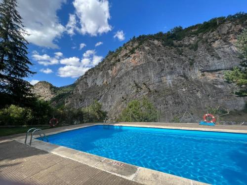 una piscina frente a una montaña en Arriel 28:24, en Escarrilla