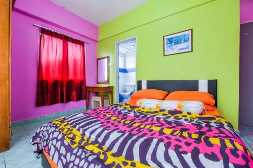 een slaapkamer met een groot bed en kleurrijke muren bij OYO Home 90466 JC Sunshine Bay Resort Apartment Port Dickson in Port Dickson