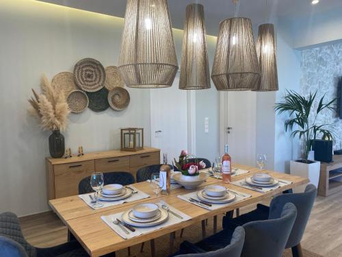 a dining room with a table with chairs and chandeliers at Villa Massari in Haraki