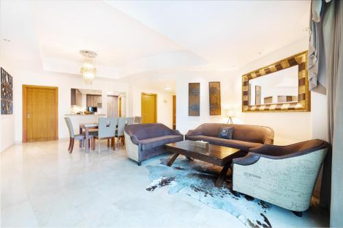 a living room with a couch and a table at Maison Privee - Spacious Apt with Beach, Pool and Marina Access in Dubai