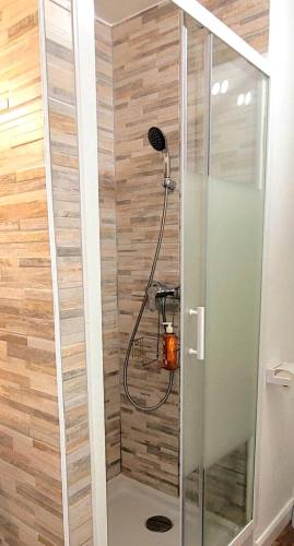 une douche dans une salle de bain avec un mur en bois dans l'établissement Studio Cocoon La Grande Motte, à La Grande Motte