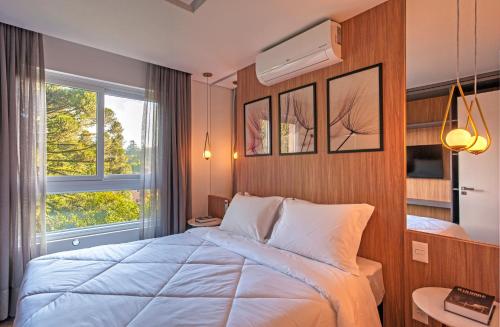 a bedroom with a large bed and a window at Cityhome Bav Residenz Gramado in Gramado
