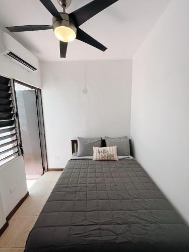 a bedroom with a bed with a ceiling fan at 3-BR in the heart of the Historical City in San Juan