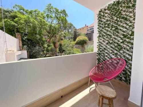 een roze stoel op een balkon met een raam bij Spacious & Quiet apartment by HelloMalaga - AZAHAR in Málaga