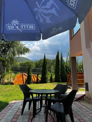 a table and chairs and an umbrella on a patio at Vila Roberta Breaza ,BV in Breaza