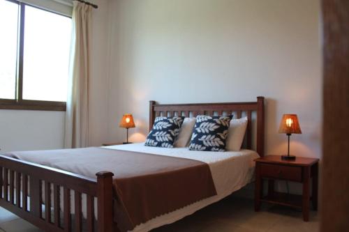 ein Schlafzimmer mit einem Bett mit zwei Lampen und einem Fenster in der Unterkunft Yiannos House in Evrykhou