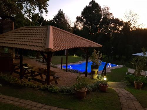 a gazebo with a picnic table next to a pool at Pumula Lodge 4 Star B&B Knysna in Knysna