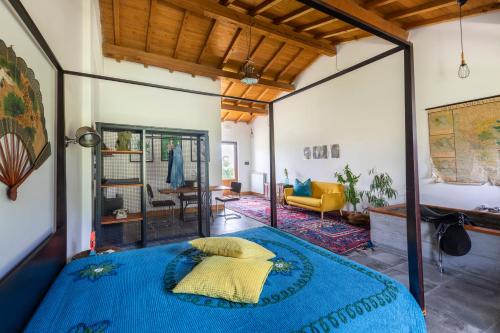 a bedroom with a blue bed and a living room at Agriturismo Braciami in Viterbo