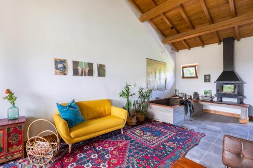a living room with a yellow couch and a fireplace at Agriturismo Braciami in Viterbo
