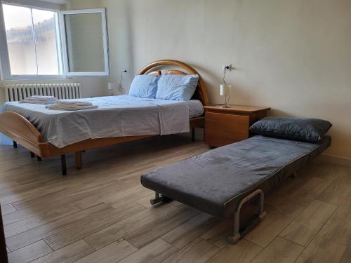 Un dormitorio con 2 camas y un banco. en Grazioso appartamento con deposito bici S. Miniato, en San Miniato